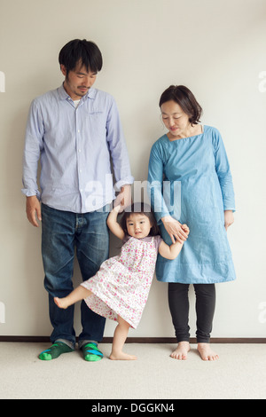 Parents holding daughter's hands, portrait Stock Photo