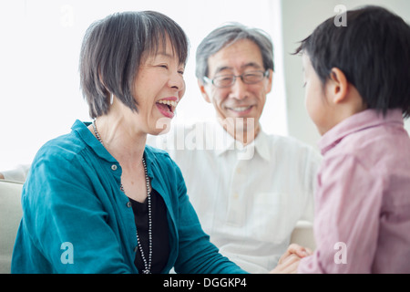 Grandparents with grandson laughing Stock Photo