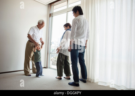 Three generation family standing by window Stock Photo