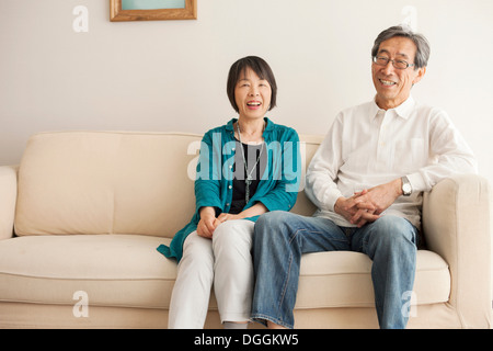 Senior couple sitting on sofa, portrait Stock Photo