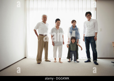 Three generation family standing by window, portrait Stock Photo