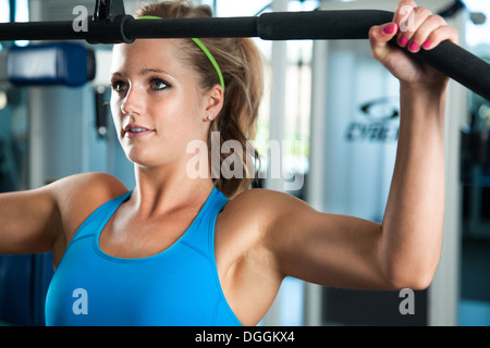 Close up of young woman pulling weights Stock Photo