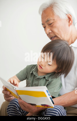 Grandfather reading to grandson Stock Photo