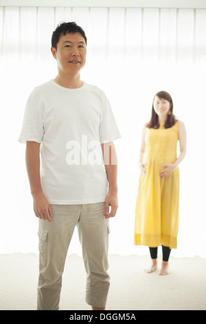 Man with pregnant woman in background, portrait Stock Photo