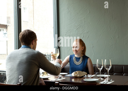 Young couple in restaurant toasting wine glasses Stock Photo