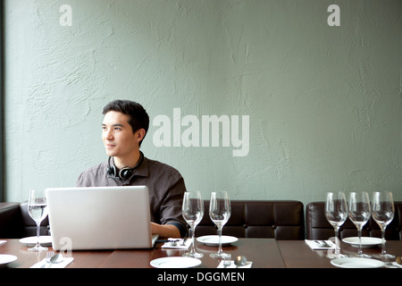 Young man using laptop in restaurant Stock Photo