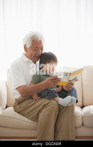 Grandfather reading to grandson Stock Photo