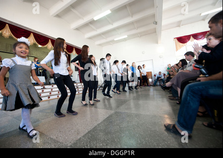 Students at Secondary School 26 in Bishkek, Krygyzstan, dance with members of the U.S. Air Forces Central Band the Blue Yonders Stock Photo