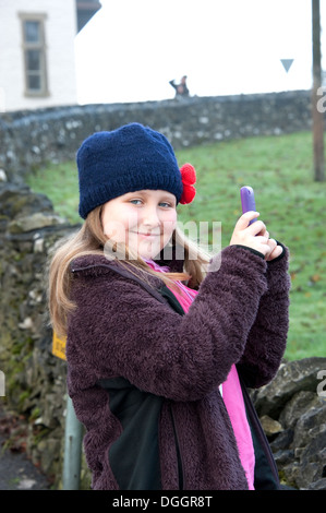 Young girl taking photo with phone smiling. FULLY MODEL RELEASED Stock Photo