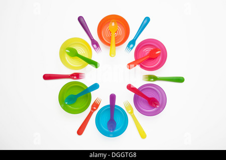 Colourful plastic plates, cups, bowls, spoons and forks Stock Photo