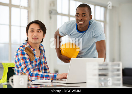 Two male engineers using laptop Stock Photo