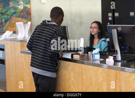African teenage student asks reference librarian a question.