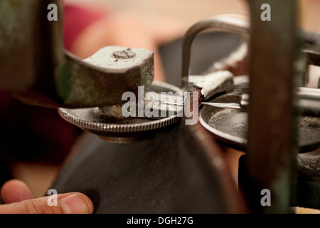Close up of person using machine to work leather Stock Photo