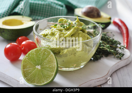 Sauce guacamole in a glass bowl over wooden background Stock Photo