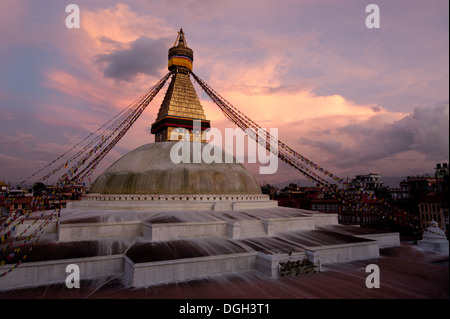 Buddhist Shrine Boudhanath Stupa with pray flags over sunset sky. Nepal, Kathmandu Stock Photo