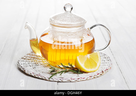 Herbal tea with lemon and rosematy in glass teapot closeup. Stock Photo