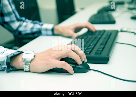 Young man typing on keyboard. Training room with computers Stock Photo