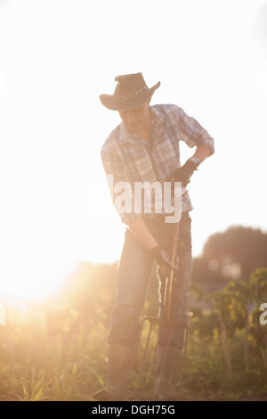 Young man working on farm in sunlight Stock Photo