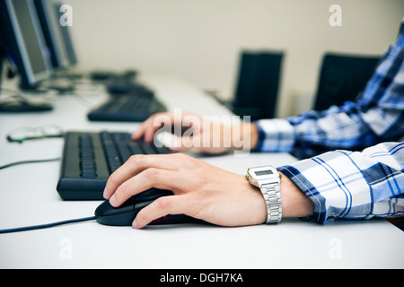 Young man typing on keyboard. Training room with computers Stock Photo