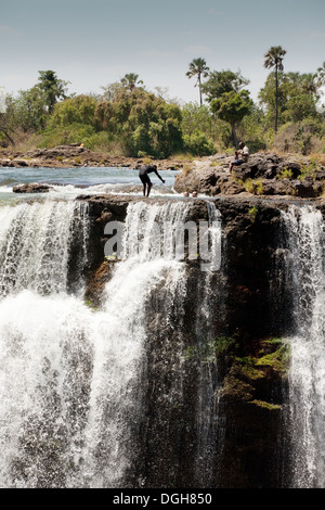 People swimming in Devils pool on the Zambian edge of the Victoria falls seen from the Zimbabwe side, Africa Stock Photo