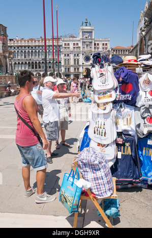 Tourists buying souvenirs from stall in St Marks square Venice, Italy, Europe Stock Photo