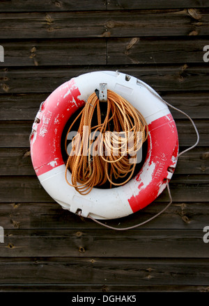 Life bouy hung on fishing hut with coiled rope Stock Photo