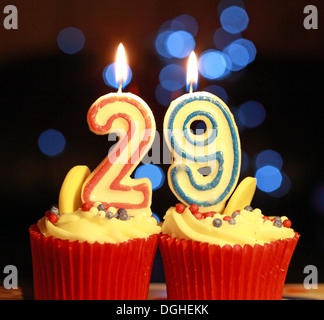 TwentyNine the number 29 as burning candles , on iced muffin, 29th birthday, with bokeh Stock Photo