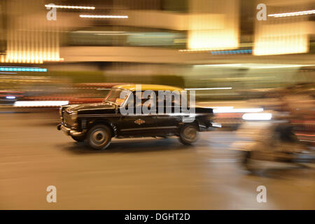 Taxi in motion on a street at night, Mumbai, Maharashtra, India Stock Photo