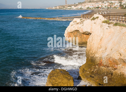 Rock armour groyne enlarging sandy beach sediment trap for longshore drift along coast, La Cala del Moral, Malaga, Spain Stock Photo