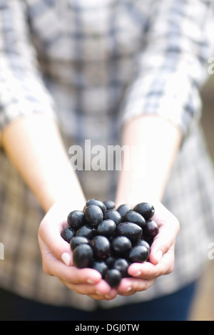 Woman with handfull of olives Stock Photo