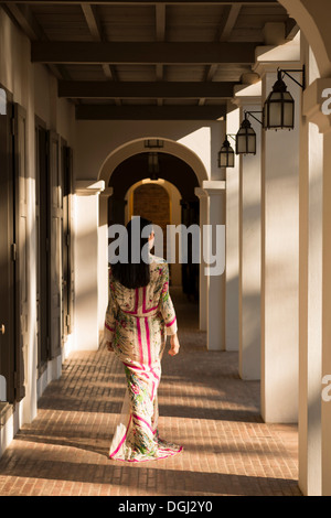 Woman walking past columns in hotel