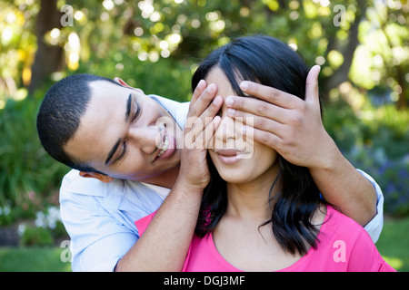 Young man covering woman's eye Stock Photo