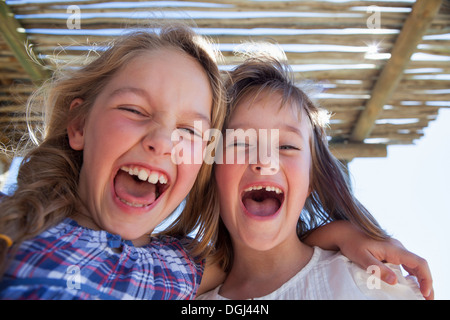 Candid portrait of two girls looking away in garden Stock Photo - Alamy