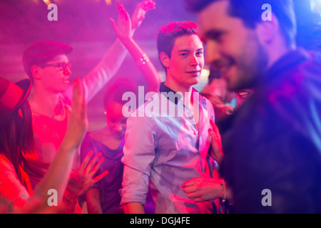 Teenage boy surrounded by group of people dancing at party Stock Photo