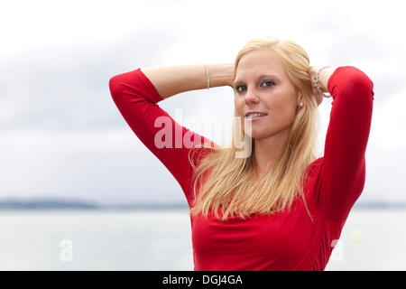 Smiling young woman running her hands through her hair, portrait Stock Photo