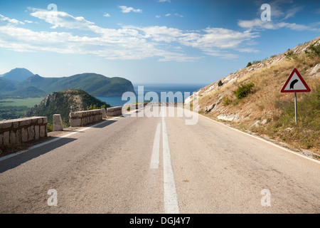 Dividing line and right turn sign on the coastal mountain highway in Montenegro Stock Photo