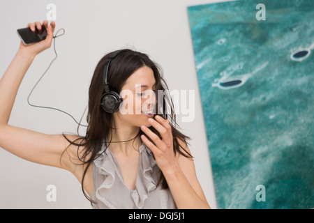 Mid adult woman listening to music through headphones
