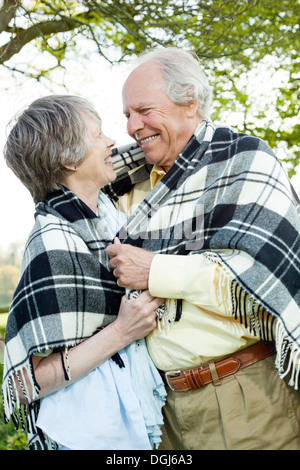 Senior couple wrapped in shawl together Stock Photo