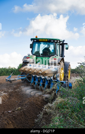 Ploughing with a modern John Deere tractor and reversible plough in North Norfolk. Stock Photo