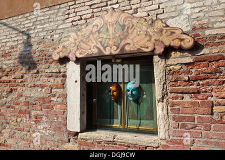 Masks on a shuttered window in Venice. Stock Photo