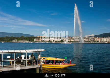 Ferry boat at the dock of the Geneva ferry company Mouettes genevoises in front of the giant fountain Jet d'Eau, with the Stock Photo