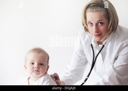 Female doctor examining baby's breathing Stock Photo