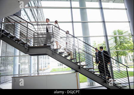 Doctors and businessmen walking up hospital staircase Stock Photo
