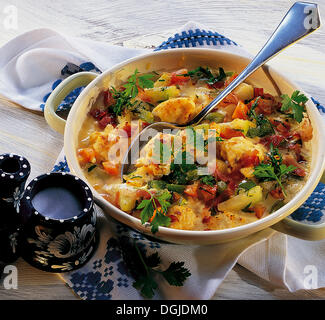 Casserole of scrambled eggs with vegetables and ham, made of spring onions, tomatoes, bell peppers, turnip cabbage and carrots Stock Photo