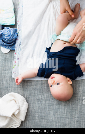 Person changing baby boy's nappy, overhead view Stock Photo