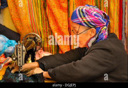 Old sewing woman of the Hmong ethnic group, old mechanical sewing machine on the market of Sapa or Sa Pa, Lao Cai province Stock Photo