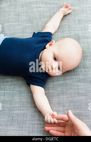 Baby boy holding person's hand Stock Photo