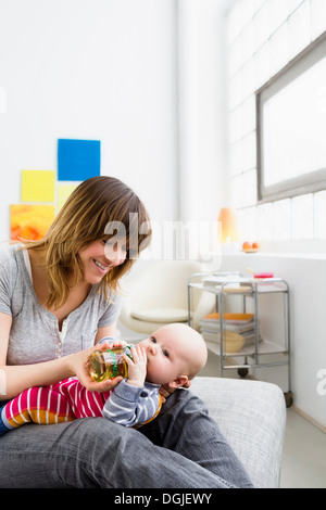 Mother feeding baby son with bottle Stock Photo