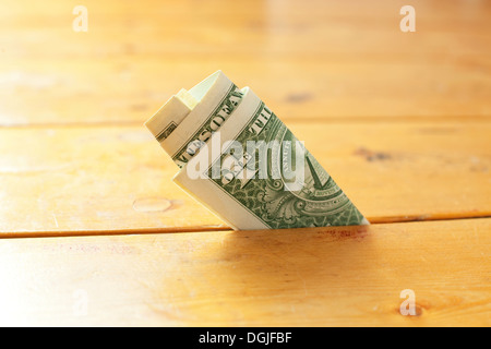 One dollar bill in between floorboards Stock Photo
