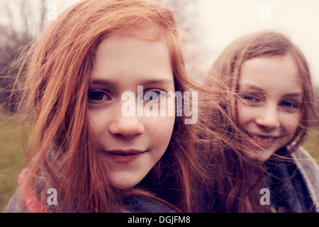 Portrait of girls wrapped in a blanket outdoors, smiling Stock Photo